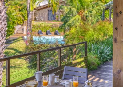 Petit-déjeuner servi en terrasse avec vue jardin et océan